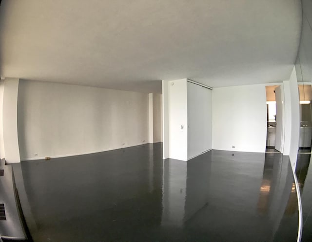 unfurnished room with finished concrete flooring