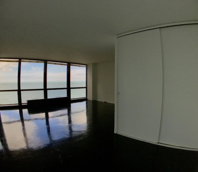 empty room with a water view and healthy amount of natural light