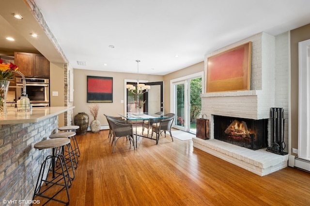 505 Jackson Ave, Glencoe, IL 60022 - dining space with light wood-style floors, a fireplace, recessed lighting, a chandelier, and baseboards