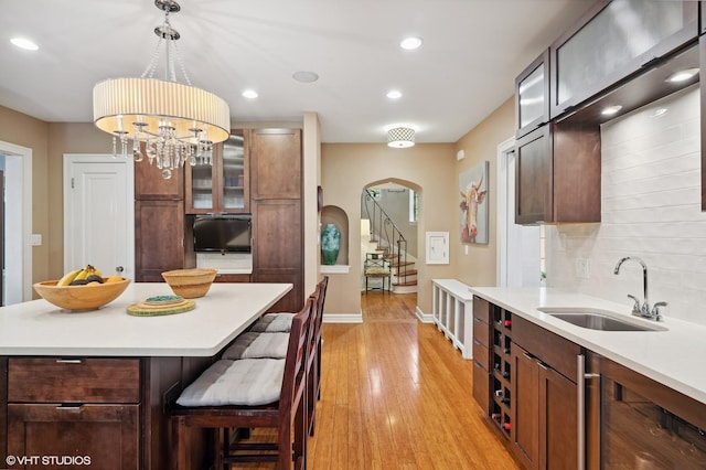 505 Jackson Ave, Glencoe, IL 60022 - kitchen with a sink, arched walkways, light wood-type flooring, light countertops, and beverage cooler