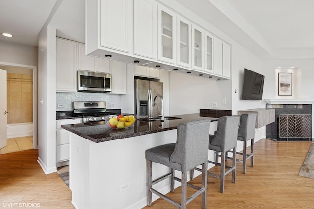2307 W Wolfram St Unit 415, Chicago, IL 60618 - kitchen featuring stainless steel appliances, a sink, white cabinetry, light wood-style floors, and recessed lighting