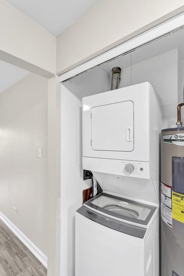 washroom with water heater, estacked washer and dryer, and light wood finished floors