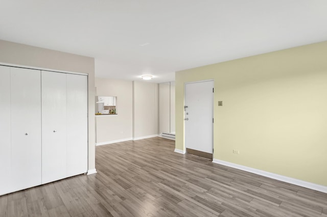 unfurnished living room with wood finished floors and baseboards
