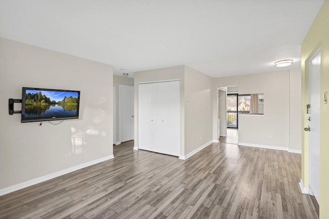 unfurnished living room featuring wood finished floors and baseboards