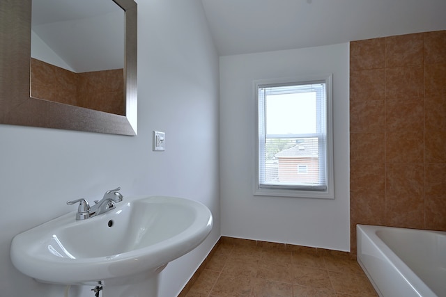 5104 N Austin Ave, Chicago, IL 60630 - bathroom with a sink, a bath, vaulted ceiling, and baseboards