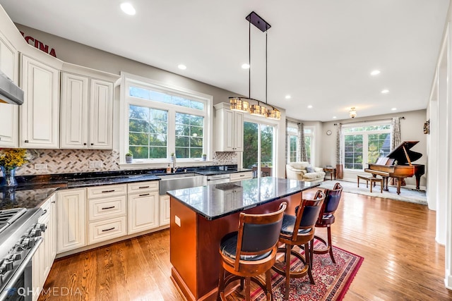 1327 Greenwood Ave, Deerfield, IL 60015 - kitchen with a sink, stainless steel range, tasteful backsplash, a breakfast bar area, and light wood finished floors