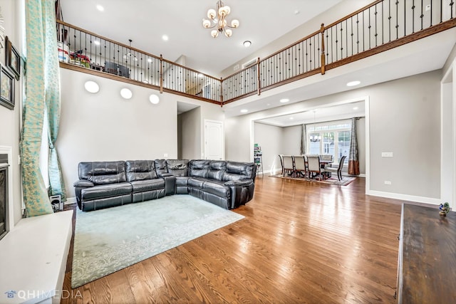 1327 Greenwood Ave, Deerfield, IL 60015 - living area featuring a chandelier, a high ceiling, wood finished floors, baseboards, and a glass covered fireplace