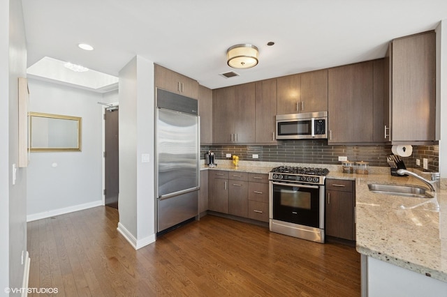 60 E Monroe St Unit 3308, Chicago, IL 60603 - kitchen with appliances with stainless steel finishes, a sink, baseboards, decorative backsplash, and dark wood-style flooring