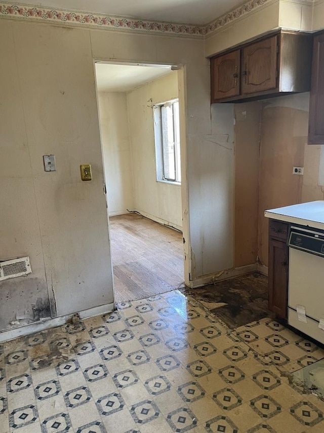 kitchen with white dishwasher, light countertops, and light flooring