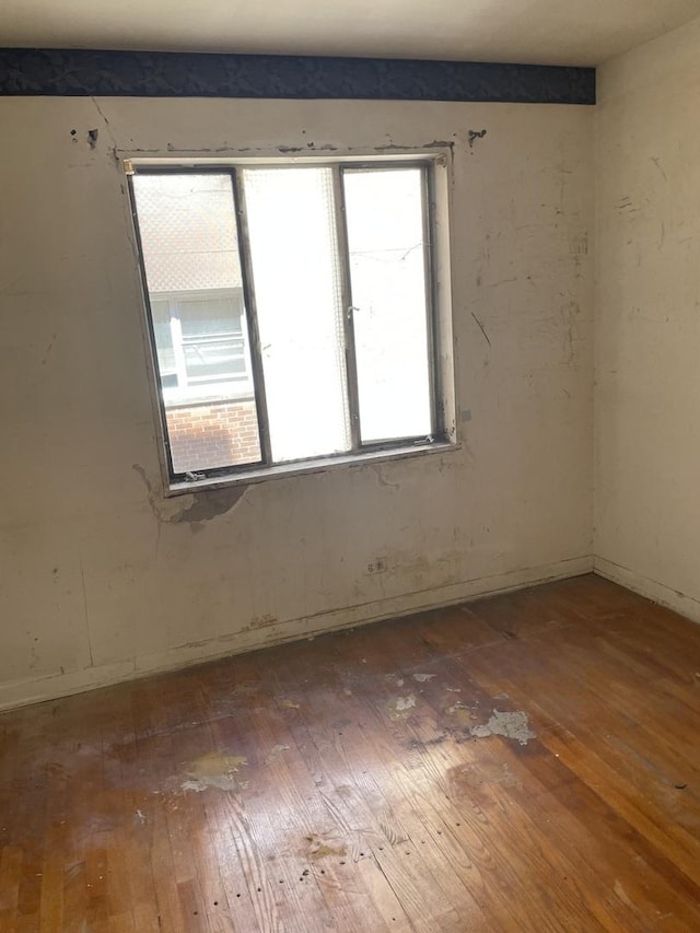 empty room with hardwood / wood-style floors and baseboards