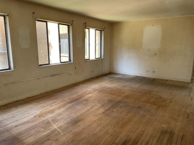 unfurnished room featuring hardwood / wood-style flooring and baseboards