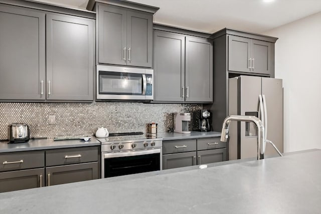 604 Cayman Way, Savoy, IL 61874 - kitchen with appliances with stainless steel finishes, gray cabinets, tasteful backsplash, and light countertops