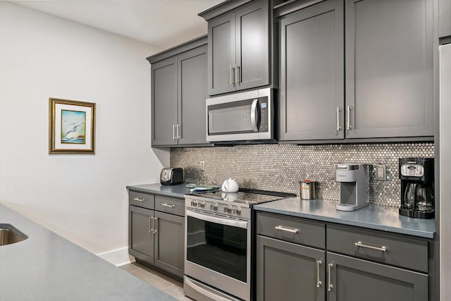 604 Cayman Way, Savoy, IL 61874 - kitchen featuring stainless steel appliances, tasteful backsplash, gray cabinets, and light tile patterned floors