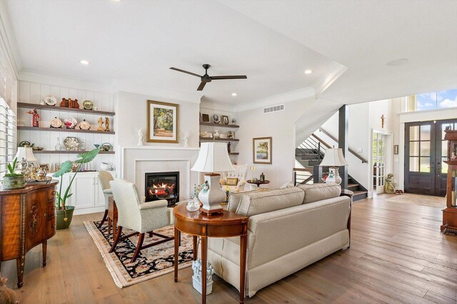 604 Cayman Way, Savoy, IL 61874 - living area with stairway, a glass covered fireplace, ornamental molding, ceiling fan, and light wood-type flooring