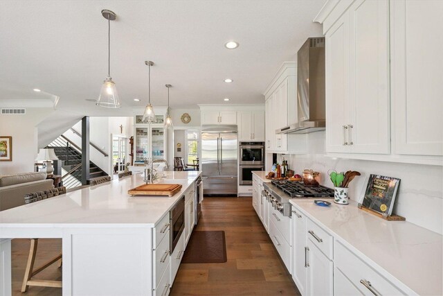 604 Cayman Way, Savoy, IL 61874 - kitchen featuring built in appliances, wall chimney exhaust hood, recessed lighting, white cabinets, and open floor plan