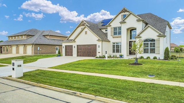 604 Cayman Way, Savoy, IL 61874 - french country home featuring concrete driveway, roof mounted solar panels, a front yard, and roof with shingles