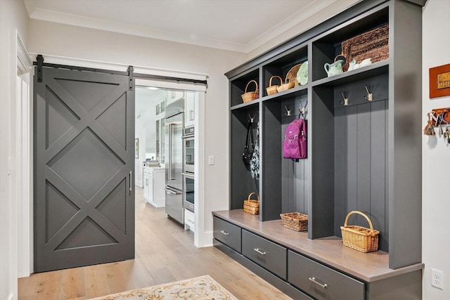 604 Cayman Way, Savoy, IL 61874 - mudroom with light wood-style floors, ornamental molding, and a barn door
