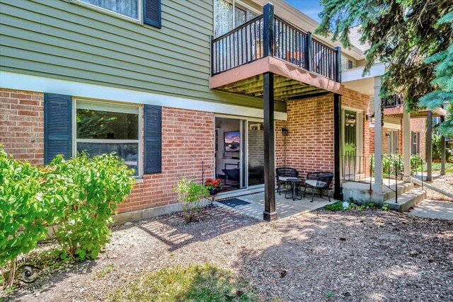 1525 Raymond Dr Unit 103, Naperville, IL 60563 - entrance to property featuring a balcony, brick siding, and a patio