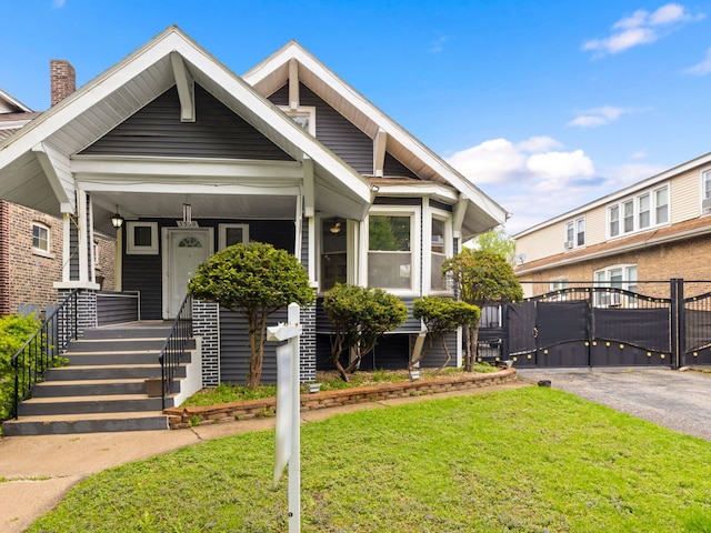 view of front of home featuring a gate, a front lawn, and a porch
