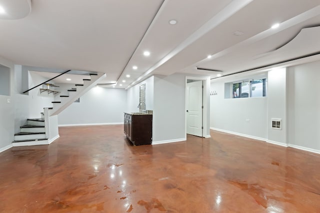 basement featuring recessed lighting, stairs, wet bar, and baseboards