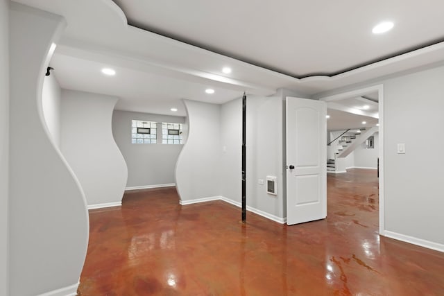 basement featuring recessed lighting, baseboards, and stairway