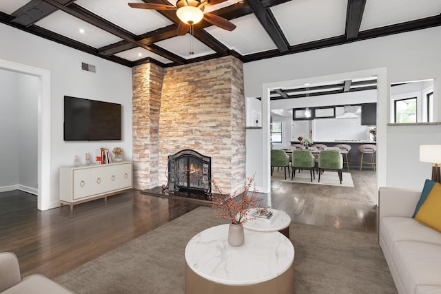 living room with wood finished floors, ceiling fan, coffered ceiling, beamed ceiling, and a fireplace