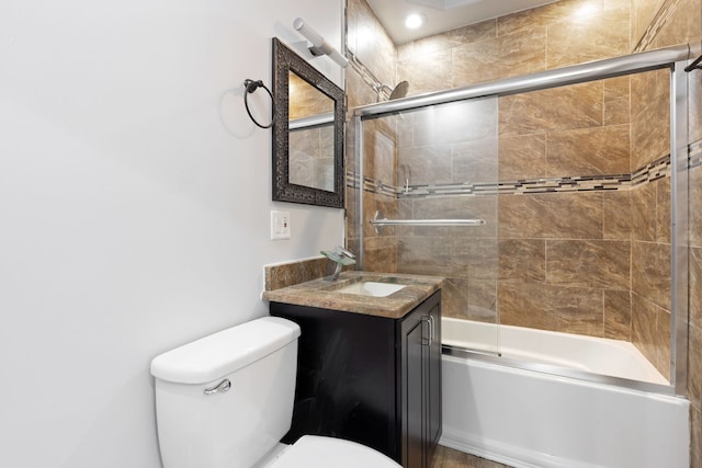 bathroom with toilet, vanity, and shower / bath combination with glass door