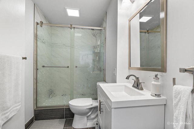 bathroom featuring a stall shower, vanity, and toilet