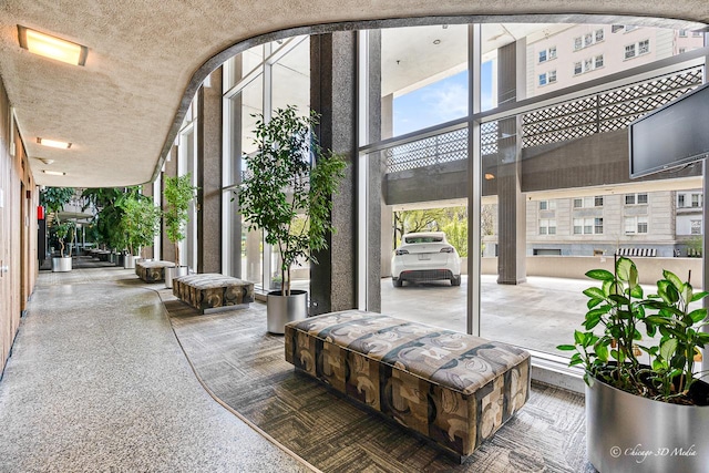 lobby with a high ceiling, expansive windows, and a textured ceiling