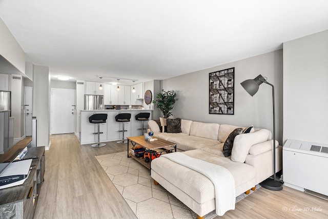 living area with light wood-style flooring and radiator