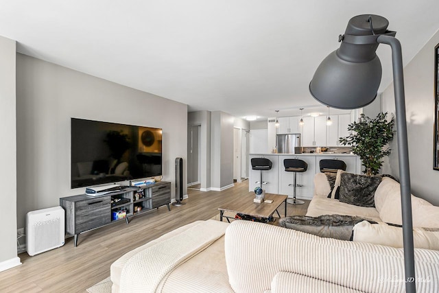 living area featuring light wood finished floors and baseboards