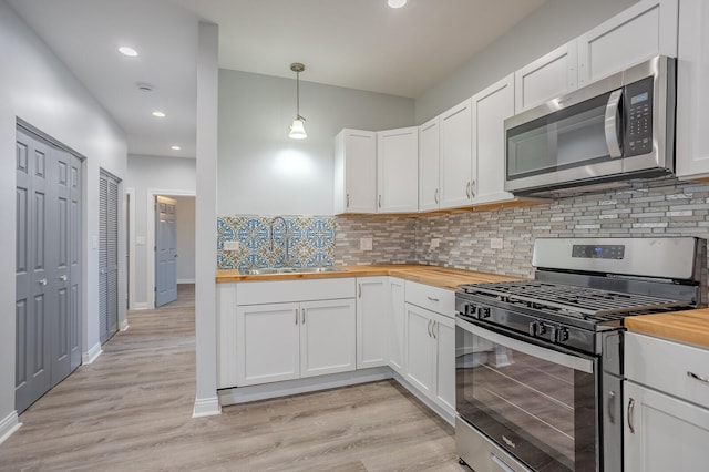 1013 W 18th Pl, Chicago, IL 60608 - kitchen with butcher block counters, stainless steel appliances, a sink, white cabinets, and recessed lighting
