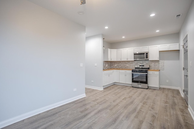 1013 W 18th Pl, Chicago, IL 60608 - kitchen with appliances with stainless steel finishes, backsplash, light wood-style floors, white cabinetry, and recessed lighting