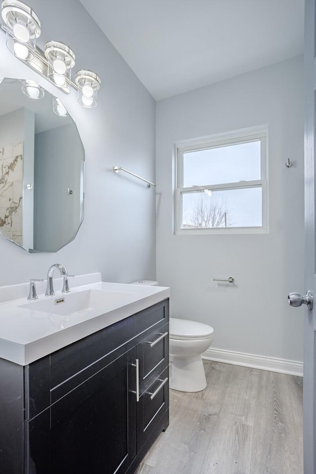 1013 W 18th Pl, Chicago, IL 60608 - bathroom featuring wood finished floors, toilet, vanity, and baseboards