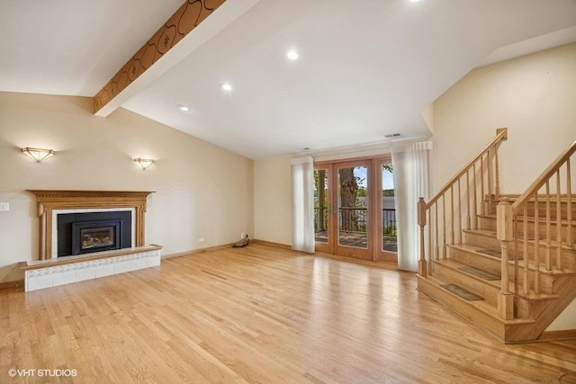 unfurnished living room with light wood-type flooring, stairway, recessed lighting, a fireplace with raised hearth, and baseboards