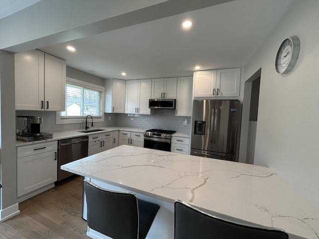 617 S Albert St, Mount Prospect, IL 60056 - kitchen with stainless steel appliances, a sink, tasteful backsplash, wood finished floors, and light stone counters
