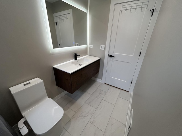 617 S Albert St, Mount Prospect, IL 60056 - bathroom with marble look tile flooring, toilet, baseboards, and vanity