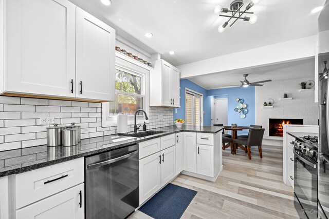 806 71st St, Darien, IL 60561 - kitchen with stainless steel dishwasher, a sink, black range with gas stovetop, light wood-type flooring, and white cabinetry