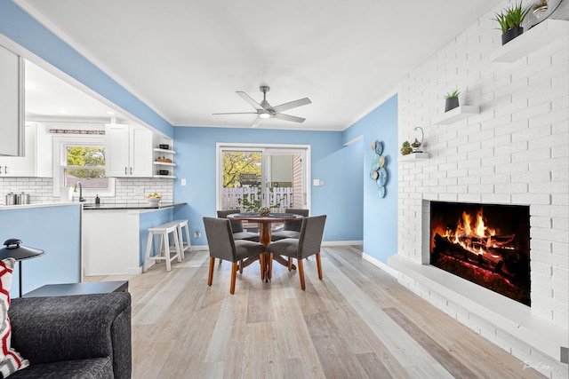 806 71st St, Darien, IL 60561 - dining area featuring light wood-style flooring, ceiling fan, a brick fireplace, healthy amount of natural light, and ornamental molding