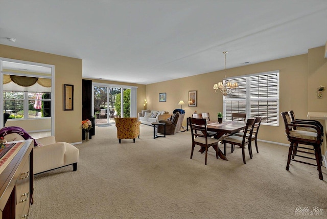 carpeted dining space with a chandelier and baseboards