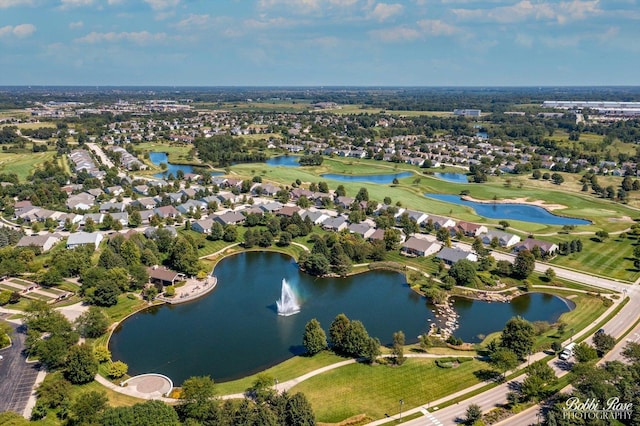 aerial view of property and surrounding area with a nearby body of water, nearby suburban area, and a golf course
