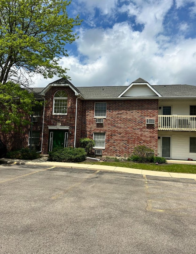 421 Leah Ln Unit 2D, Woodstock, IL 60098 - view of front of property with uncovered parking, brick siding, and a shingled roof