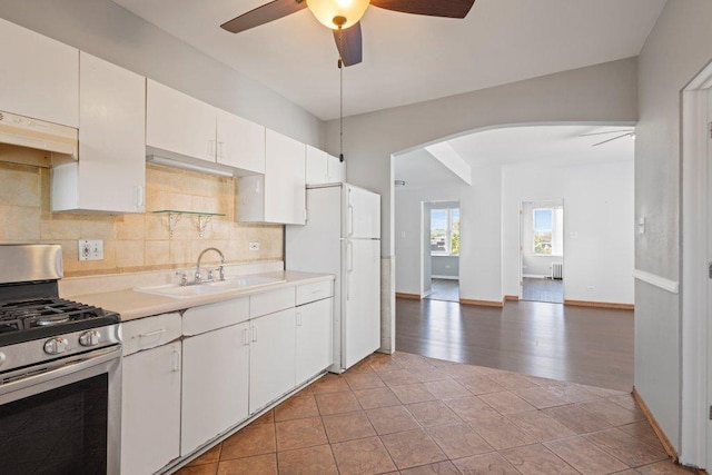 1637 S 48th Ct Unit 9, Cicero, IL 60804 - kitchen with stainless steel gas range, under cabinet range hood, a ceiling fan, a sink, and arched walkways