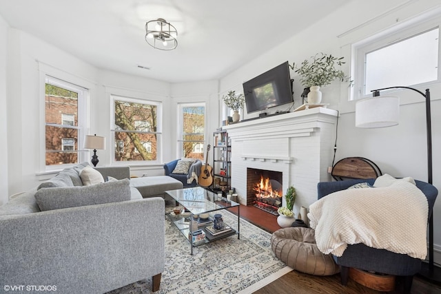 5830 N Glenwood Ave, Chicago, IL 60660 - living room featuring healthy amount of natural light, wood finished floors, and a brick fireplace