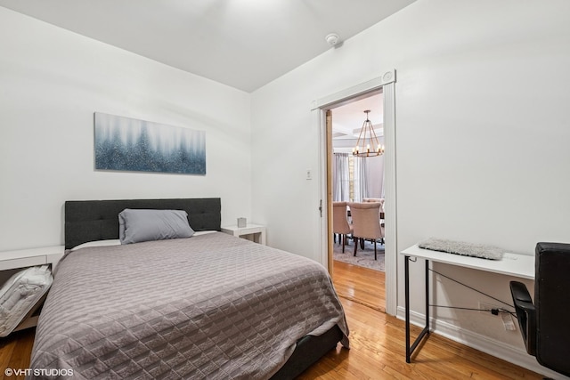5830 N Glenwood Ave, Chicago, IL 60660 - bedroom featuring a chandelier and wood finished floors