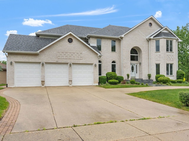 420 Ford Ln, Bartlett, IL 60103 - view of front facade featuring an attached garage, driveway, a shingled roof, and brick siding