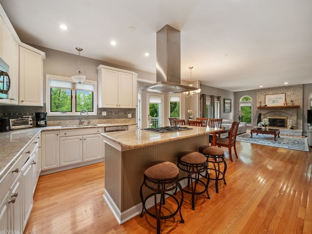 420 Ford Ln, Bartlett, IL 60103 - kitchen featuring island range hood, a sink, open floor plan, a center island, and tasteful backsplash
