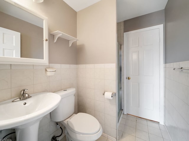 420 Ford Ln, Bartlett, IL 60103 - bathroom featuring tile walls, toilet, a stall shower, a sink, and a wainscoted wall