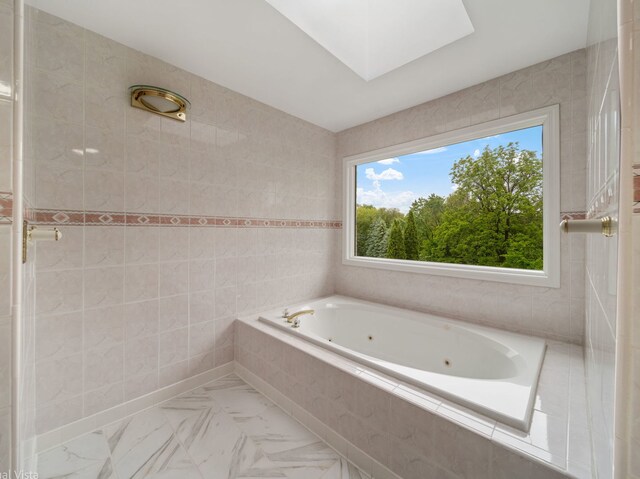 420 Ford Ln, Bartlett, IL 60103 - bathroom featuring a jetted tub, a skylight, and marble look tile flooring