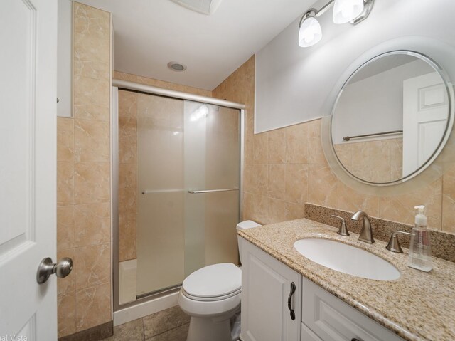 420 Ford Ln, Bartlett, IL 60103 - bathroom featuring tile walls, vanity, a stall shower, toilet, and tile patterned flooring